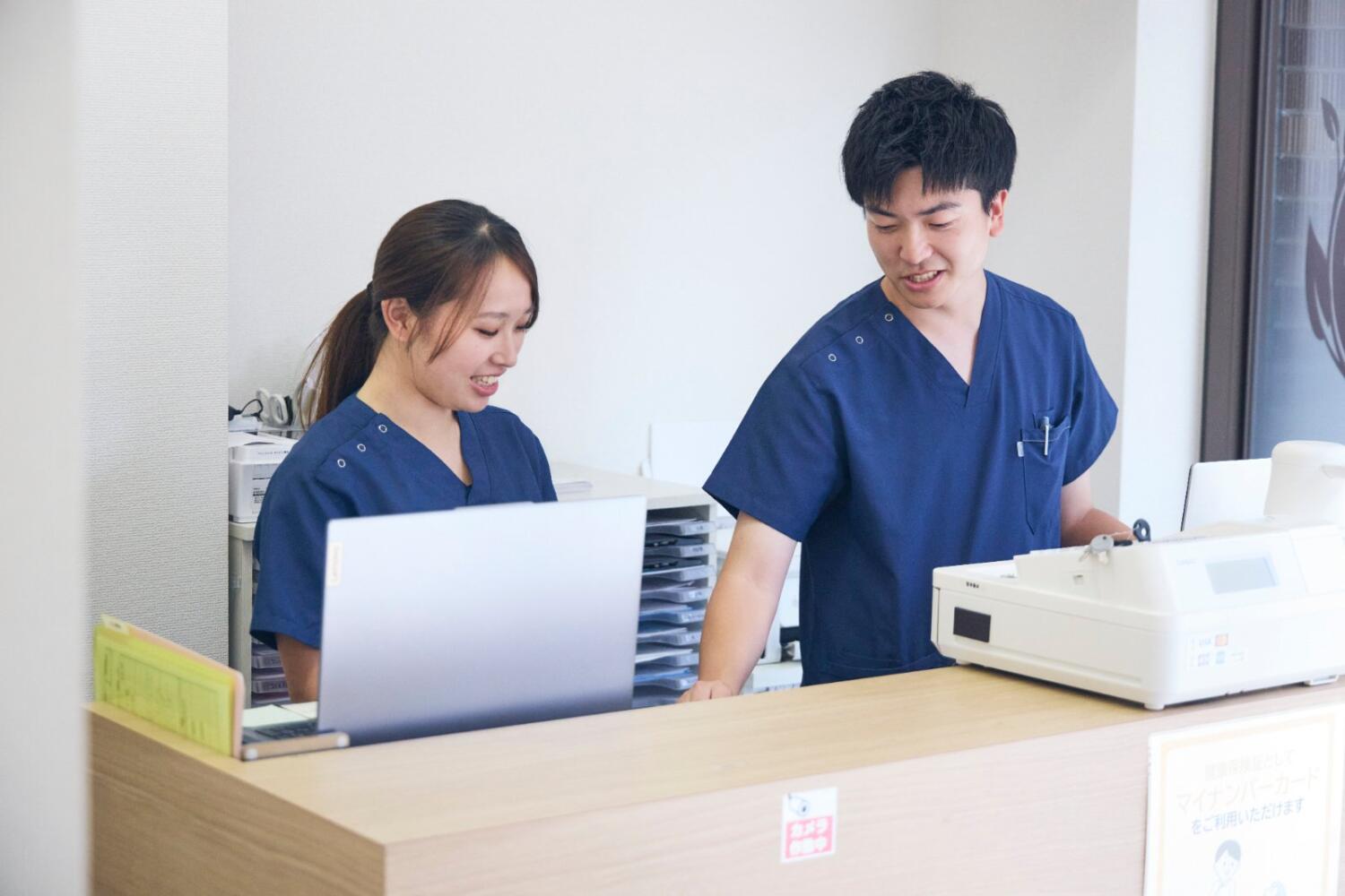 受付で笑顔で話すまごころグループのスタッフ